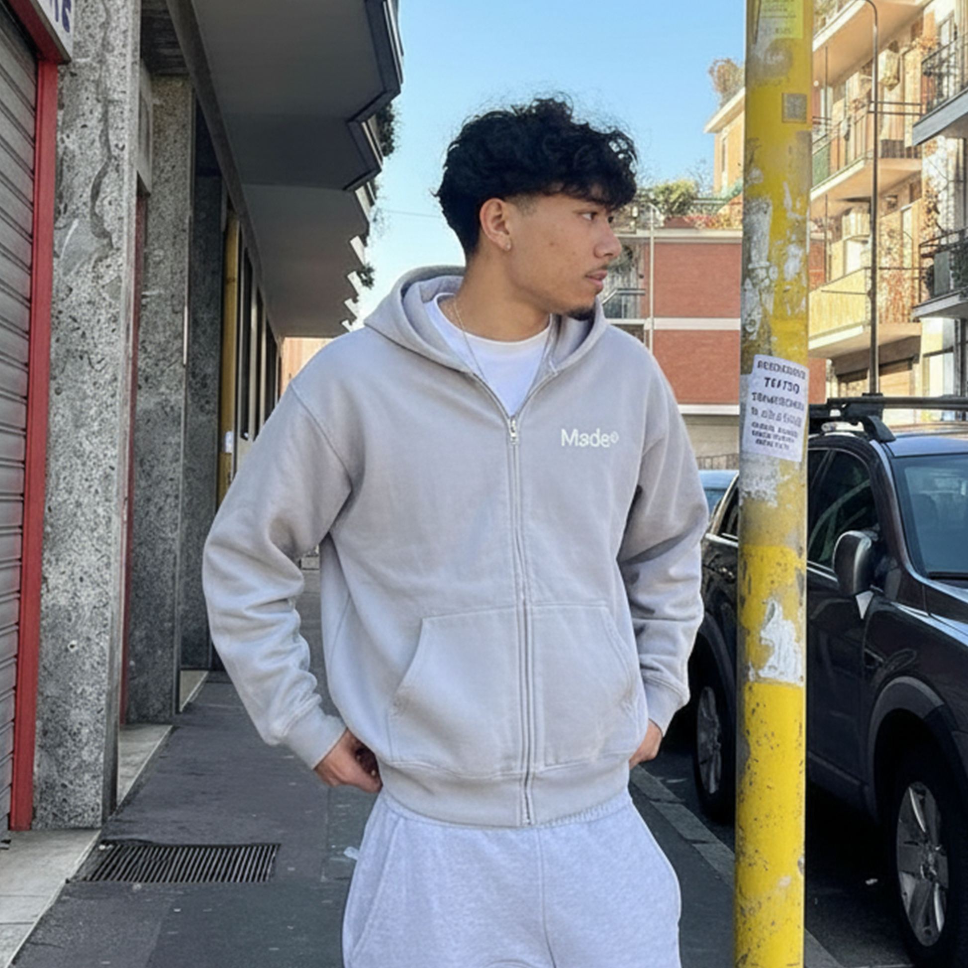 Model wearing a gray "Made®" zip-up hoodie.