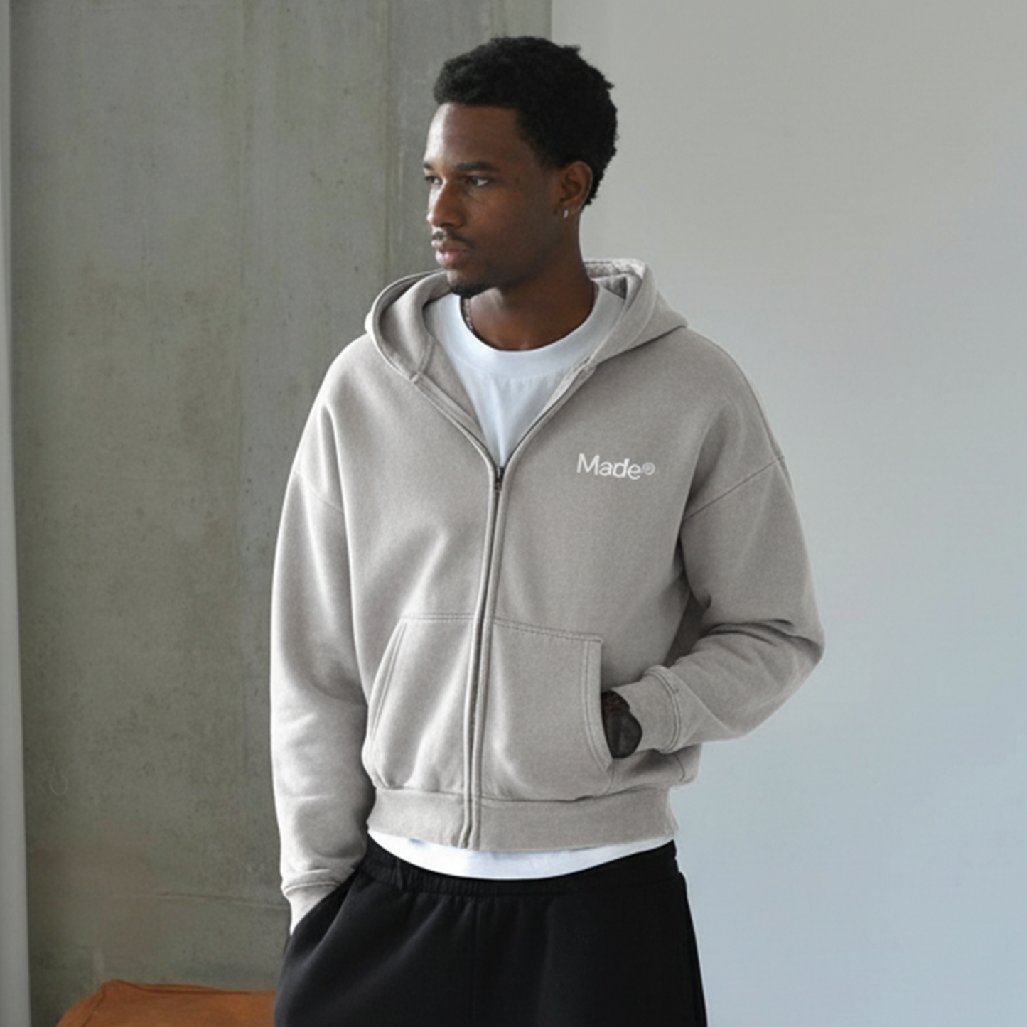 Model wearing a gray "Made®" zip-up hoodie.