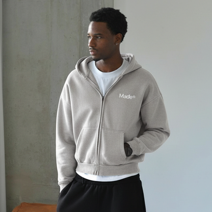 Model wearing a gray "Made®" zip-up hoodie.