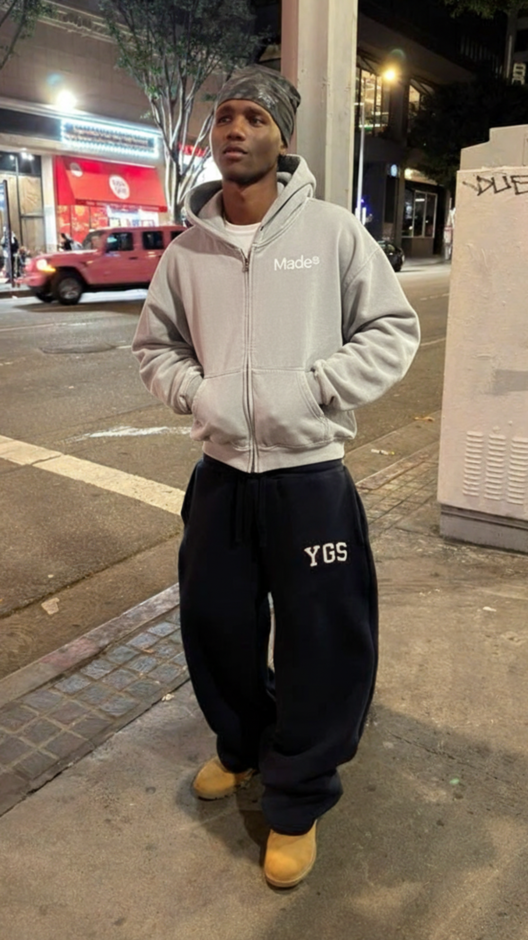 Model wearing a gray "Made®" zip-up hoodie. (Vertical)