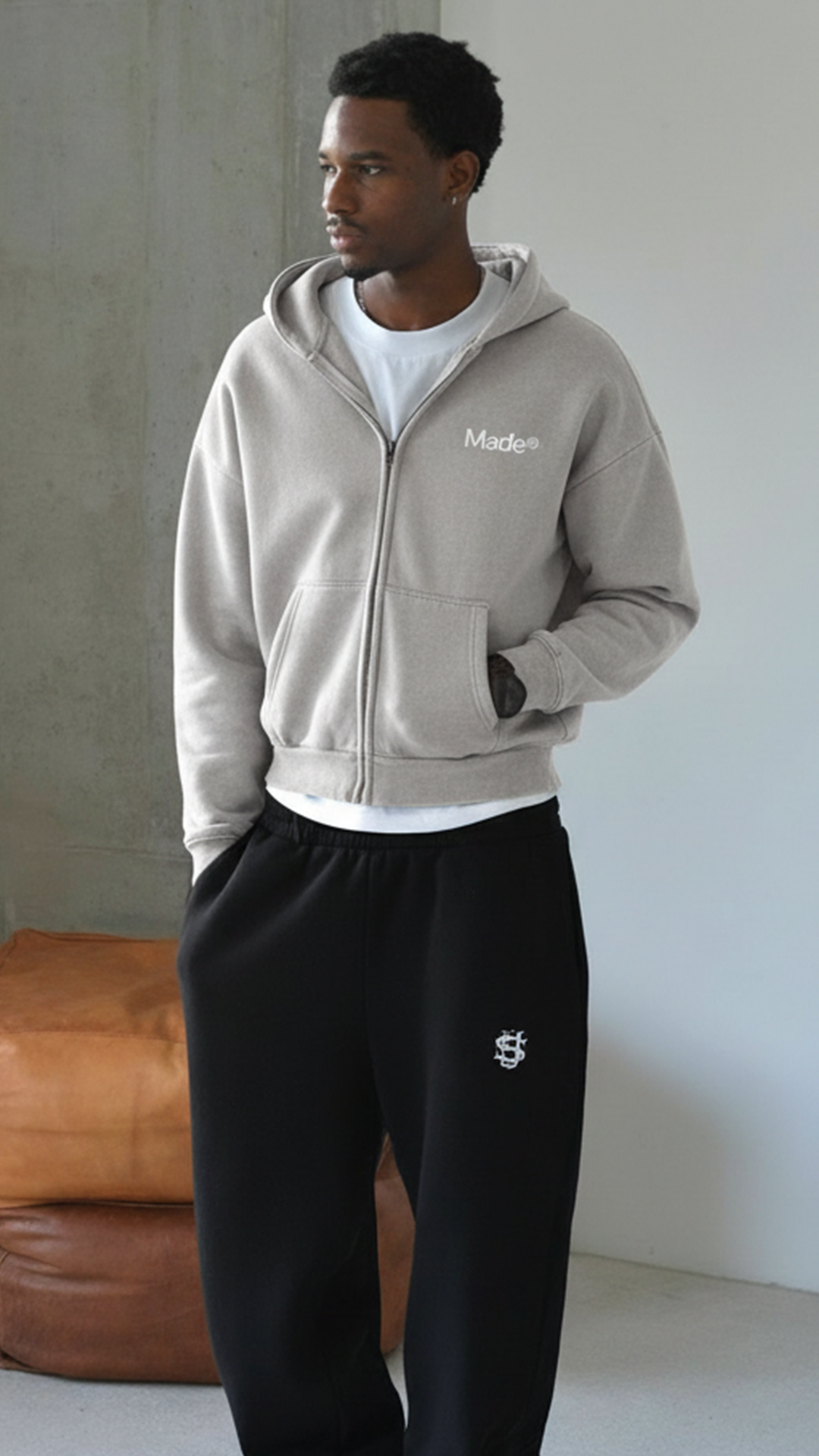 Model wearing a gray "Made®" zip-up hoodie. (Vertical)