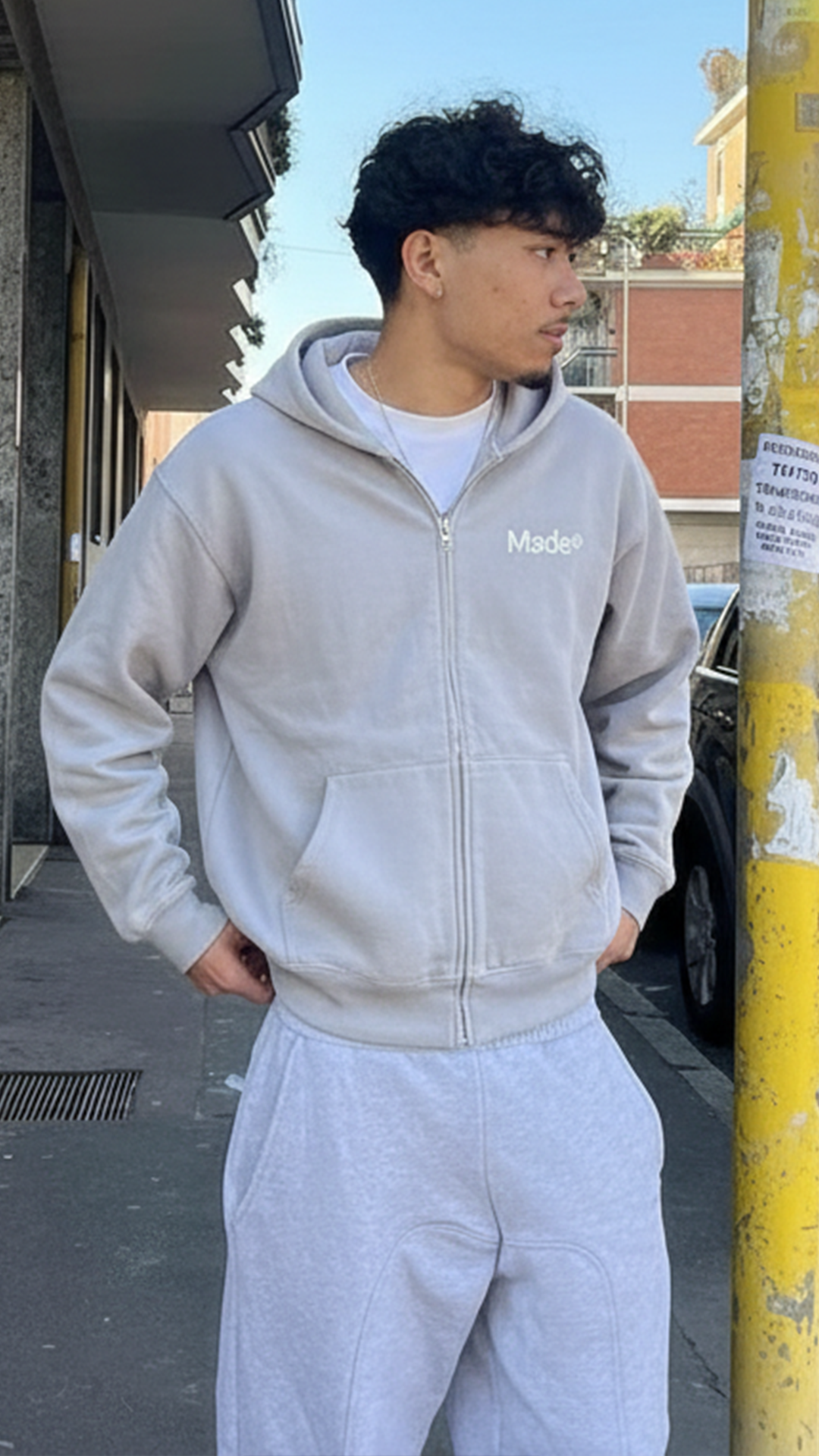 Model wearing a gray "Made®" zip-up hoodie. (Vertical)